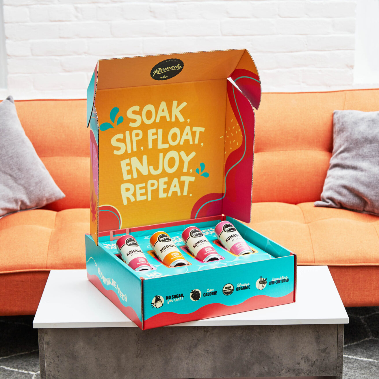 A box with a bottle of soda sitting on top of a couch.