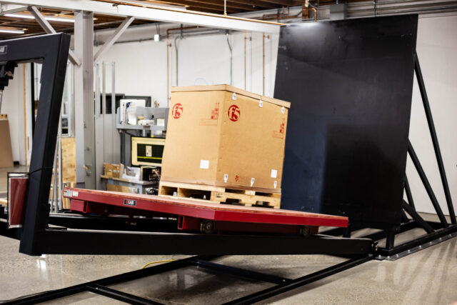 A machine is lifting a box in a warehouse.