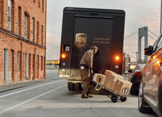 A man loading up a truck with boxes.