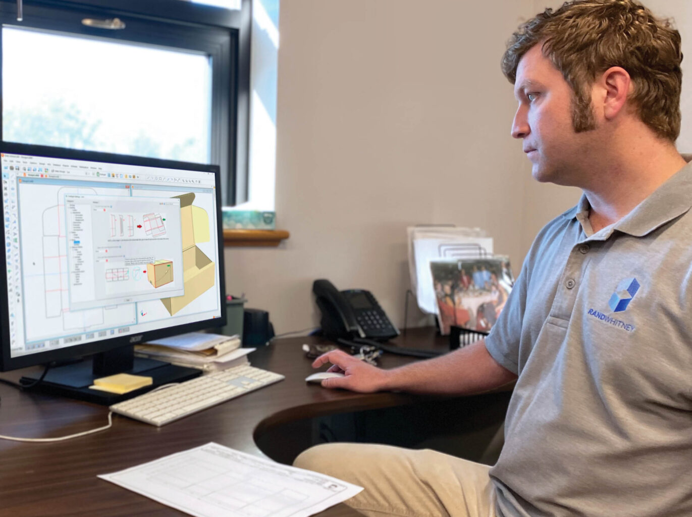 A man sitting at a desk looking at a computer screen.