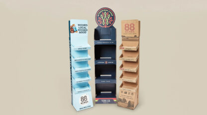 Three cardboard display stands with a variety of products on it.